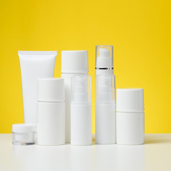 empty white plastic tubes and jars for cosmetics. Packaging for cream, gel, serum, advertising and product promotion, mock up