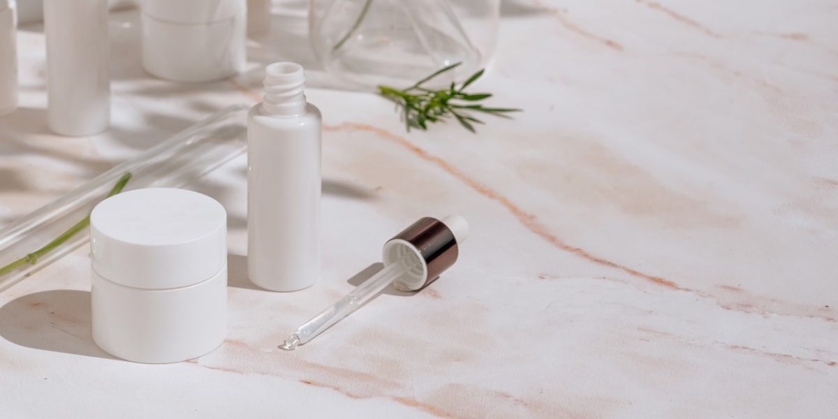 Natural cosmetic products in white packaging with laboratory glassware. Science and skincare concept Natural cosmetic products in white packaging with laboratory glassware. Science and skincare concept Compositions with cosmetic packaging in a medical style and plant shadows. Front view, selective focus