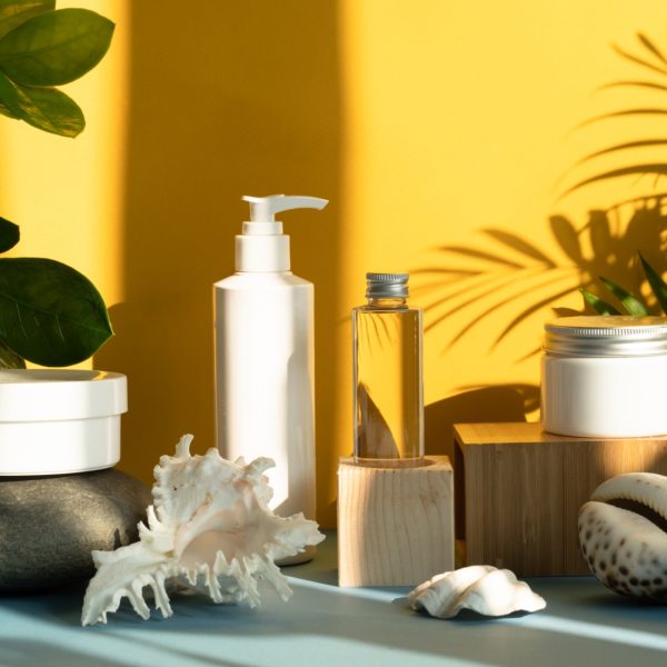 White cream packaging for your presentation cosmetic Simple skincare product for presentation your cosmetics , white tube mock-ups set on natural wooden and stone podiums. Yellow background with shadow .